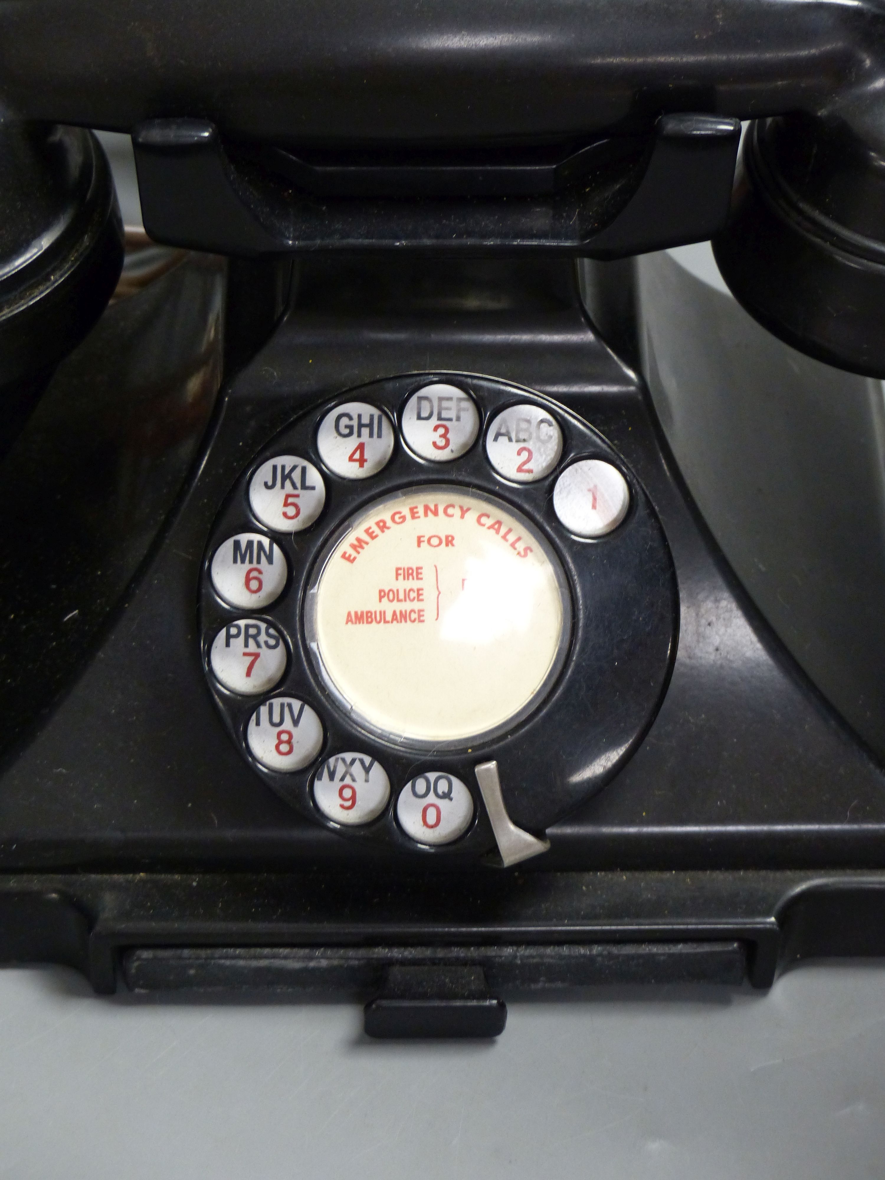 A vintage stick telephone and a black Bakelite telephone